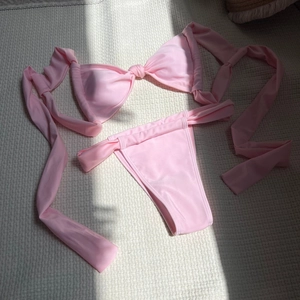 Detailed flat lay of pink bandeau bikini set with tie knots and high-waisted bottoms