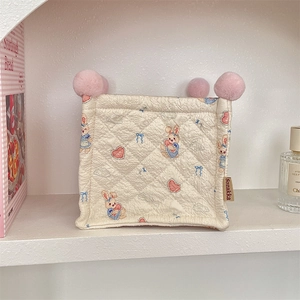 Detail view of a quilted fabric storage basket with cute bunny and heart patterns