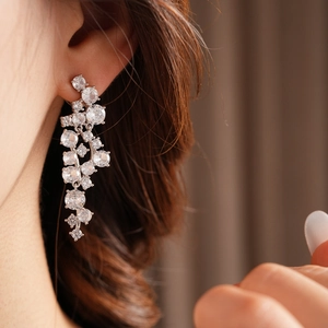 Close-up of silver tassel earrings with irregular zircons on a model for a chic look