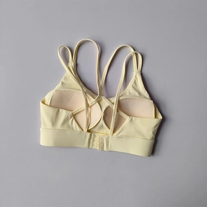 Detailed back view of yellow sports bra with thin cross straps and adjustable hook closure