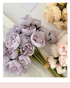Detailed top view of purple and beige artificial rose bouquets on a vintage paper