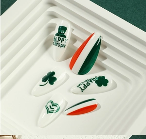 Detail of St. Patrick's Day press-on nails with clover and festive green hat designs