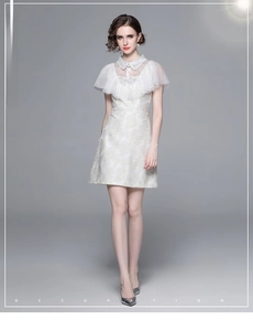 Détail du tissu jacquard blanc avec col en dentelle et nœud élégant sur la robe