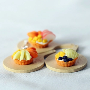 Miniature fruit pie dollhouse food models on wooden trays with colorful sliced fruits