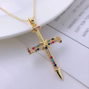 Detailed close-up of a 14K gold cross sword pendant with vibrant multicolor zircon stones