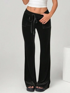 Detail of black velvet flared trousers showing high-quality texture and drawstring waist