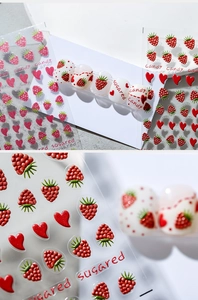 Detailed 3D embossed raspberry and heart nail art stickers on white acrylic nails