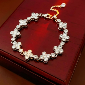 Macro detail of silver zircon clover bracelet on a premium red wooden jewelry box