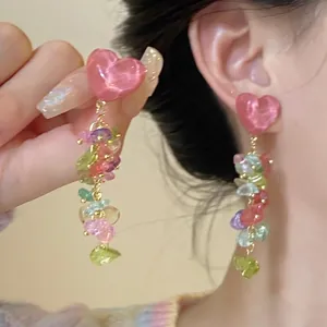 Detailed view of vintage-style flower earrings featuring colorful stone tassels and pink heart