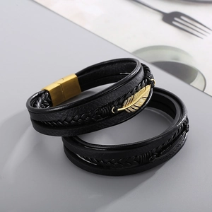 Detail of multi-layer leather bracelets with feather charms and brushed magnetic clasps