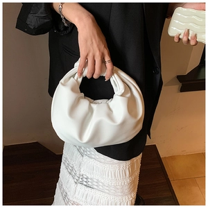 Detail of white ruched cloud bag featuring a signature knotted handle and soft leather texture