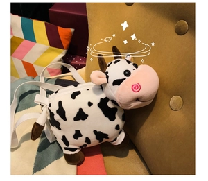 Detail of cute plush cow backpack featuring soft fabric and white shoulder straps