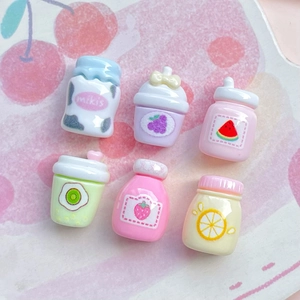 Flat lay of colorful mini resin fruit juice bottles with cherry and grape designs