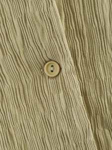 Close-up of beige long sleeve set showing vertical pleated texture and matching button