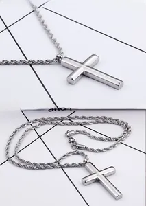 Detail of polished stainless steel cross pendant with stylish twisted rope chain link