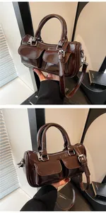 Close-up of deep brown glossy saddle bag featuring dual front pockets and silver hardware