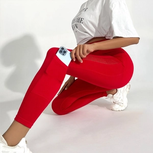 Détail de legging yoga rouge taille haute avec poche latérale et découpes laser aérées