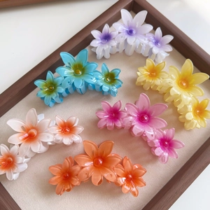 Macro detail of high-quality resin flower hair claws in multiple candy colors for styling
