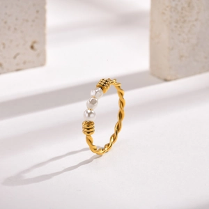 Twisted gold stainless steel ring featuring three white pearls on a minimalist band