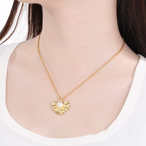 Golden necklace featuring a crumpled leaf heart pendant with an embedded white pearl