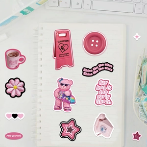 Close-up of pink aesthetic stickers including teddy bear and coffee on a notebook