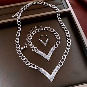 Macro detail of silver V-shaped jewelry set with crystal inlay in premium display case