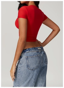 Detail showing red slim-fit short T-shirt and washed blue denim jeans from a side view