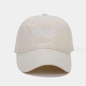 Dettaglio del ricamo baby girl in stile gotico sul cappellino da baseball beige