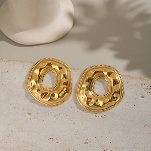 Macro shot of gold-plated irregular donut earrings with high-shine hammered texture