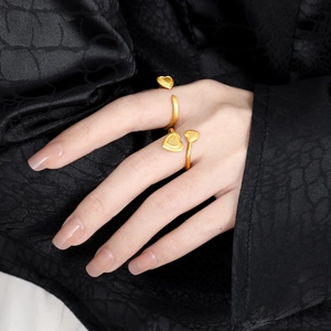 Minimalist brushed gold heart-shaped adjustable rings worn on finger with elegant finish