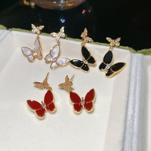 Detailed view of butterfly stud earrings with zircon and enamel in gold-plated alloy