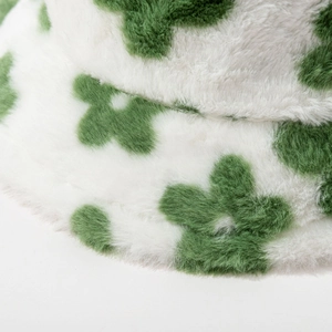 Plush faux fur bucket hat with green flower pattern on white, soft winter headwear