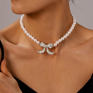 Collana di perle vintage con ciondolo a fiocco di strass lucidi indossata da modella