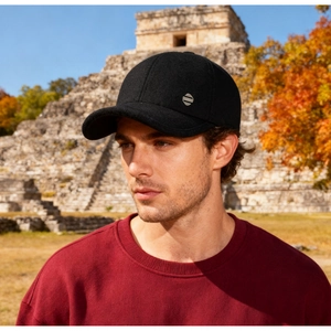 Close-up of minimalist black winter baseball cap with plush lining and metal emblem