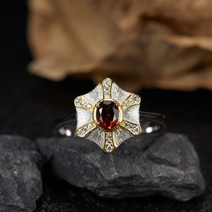 Macro detail of S925 silver ring with red garnet stone and gold hexagram setting