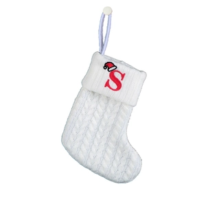 Close-up of white knit Christmas stocking with red letter S embroidery and cable texture