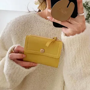 Bright yellow trifold leather wallet with rose gold snap button and metal zipper