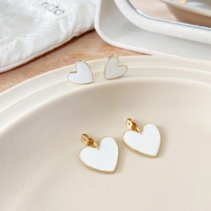 Macro detail of vintage heart jewelry set with white enamel and golden plating