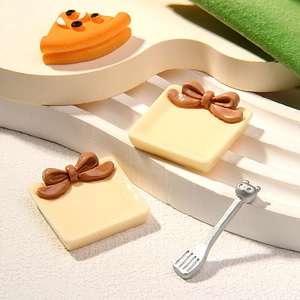 Miniature resin dollhouse set with orange waffle pizza, bow plates, and silver spatula