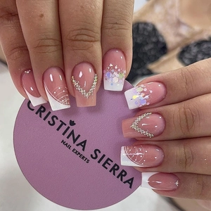 Detail of French press-on nails with pink base, silver glitter, and V-shaped rhinestones