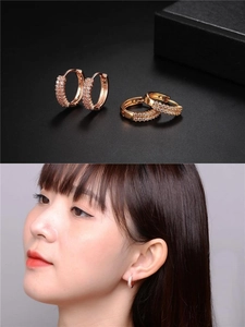 Close-up of double-row pavé zircon hoop earrings in gold and rose gold finishes
