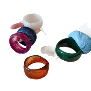 Stack of chunky acrylic resin bangles featuring marble patterns and diverse colors