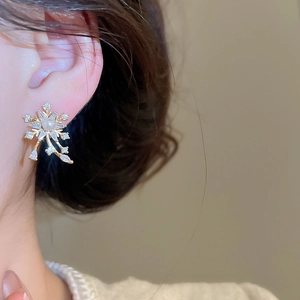 Macro side view of elegant snowflake earrings with pearl and zircon on model's ear