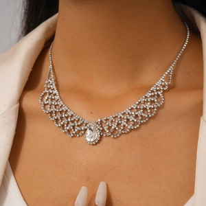 Detail of luxury teardrop crystal pendant necklace in silver grid design on model