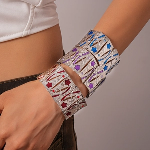 Silver wide cuff bracelet with star patterns and colorful enamel inlay shown on wrist