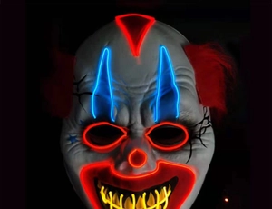 Close-up of glowing LED scary clown mask with red hair and EL wire for Halloween