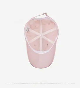Detail of pink baseball cap interior showing white sweatband and adjustable metal buckle