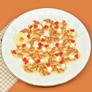 Close-up of miniature resin donuts and Christmas wreath decors in a white plate