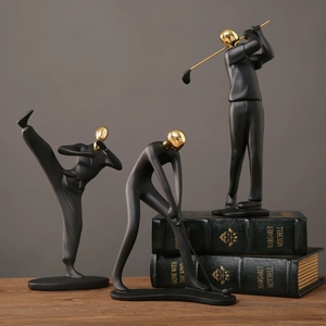 Ensemble de trois sculptures sportives en résine noir et or sur livres anciens
