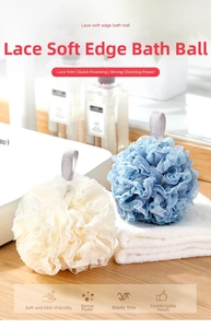 Close-up of soft lace-edged bath sponges in cream and blue colors on a clean white towel